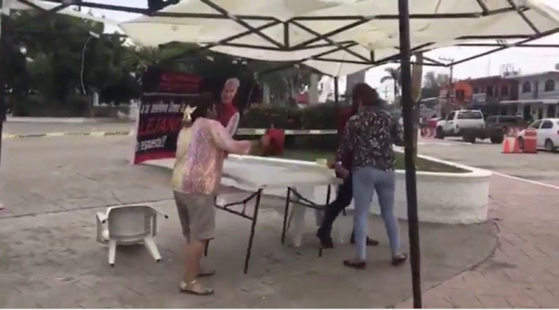 Mujer arremete contra stand para recabar firmas para juicio a expresidentes