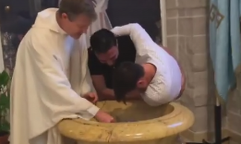 Se viraliza momento en que cargan a joven como bebé para bautizarlo en la pila (VIDEO)y